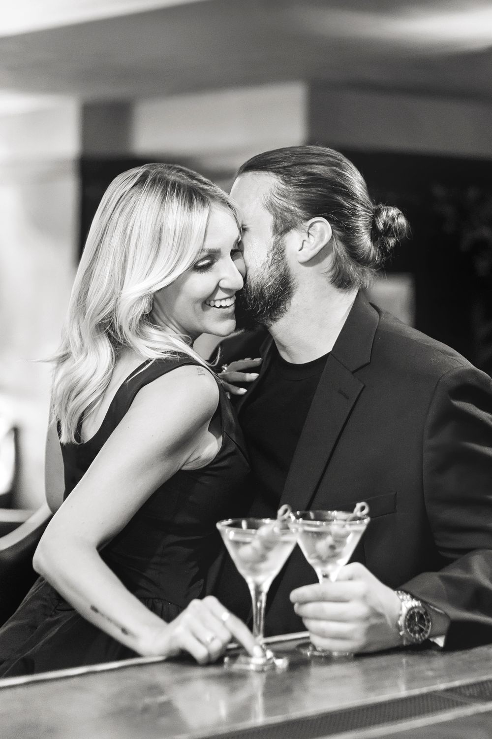 A romantic black and white photo series showing a couple sharing intimate moments at a bar with martini glasses.