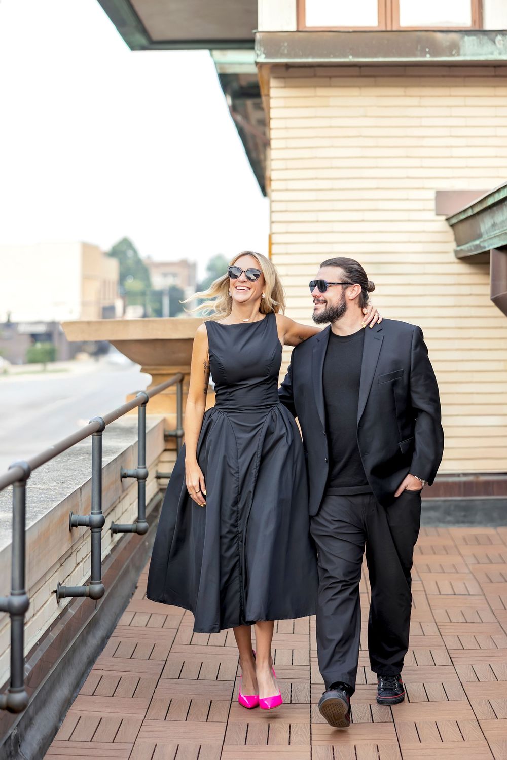 A couple in matching black outfits pose together on brick steps in a series of candid shots.