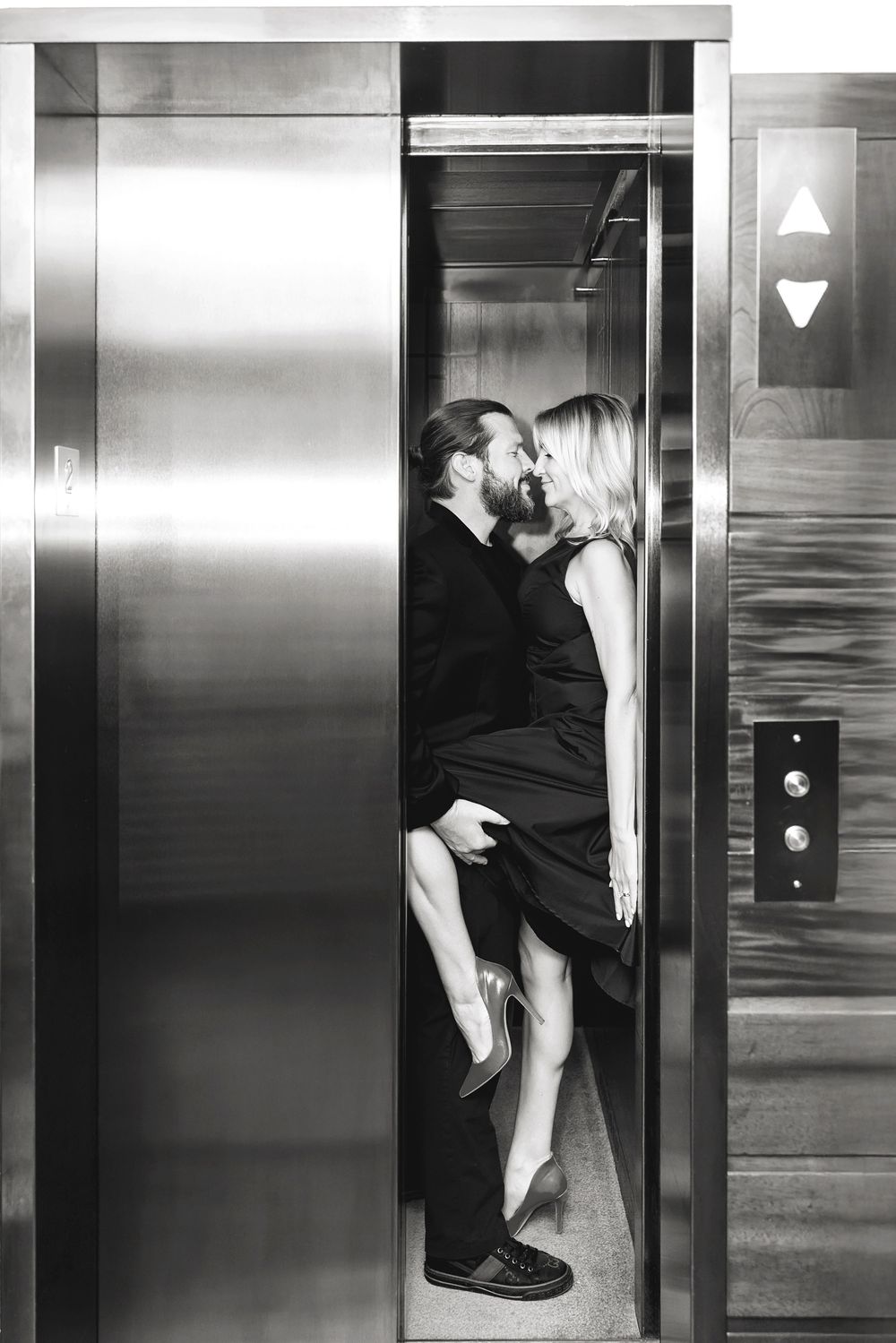 Black and white sequence showing couple's playful elevator interaction with dramatic lighting and composition.