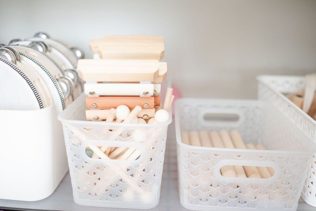 White woven storage baskets organizing aesthetic musical instruments arranged on a self