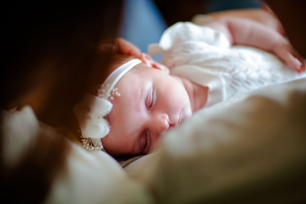 Peaceful sleeping newborn baby wrapped in soft white blankets.