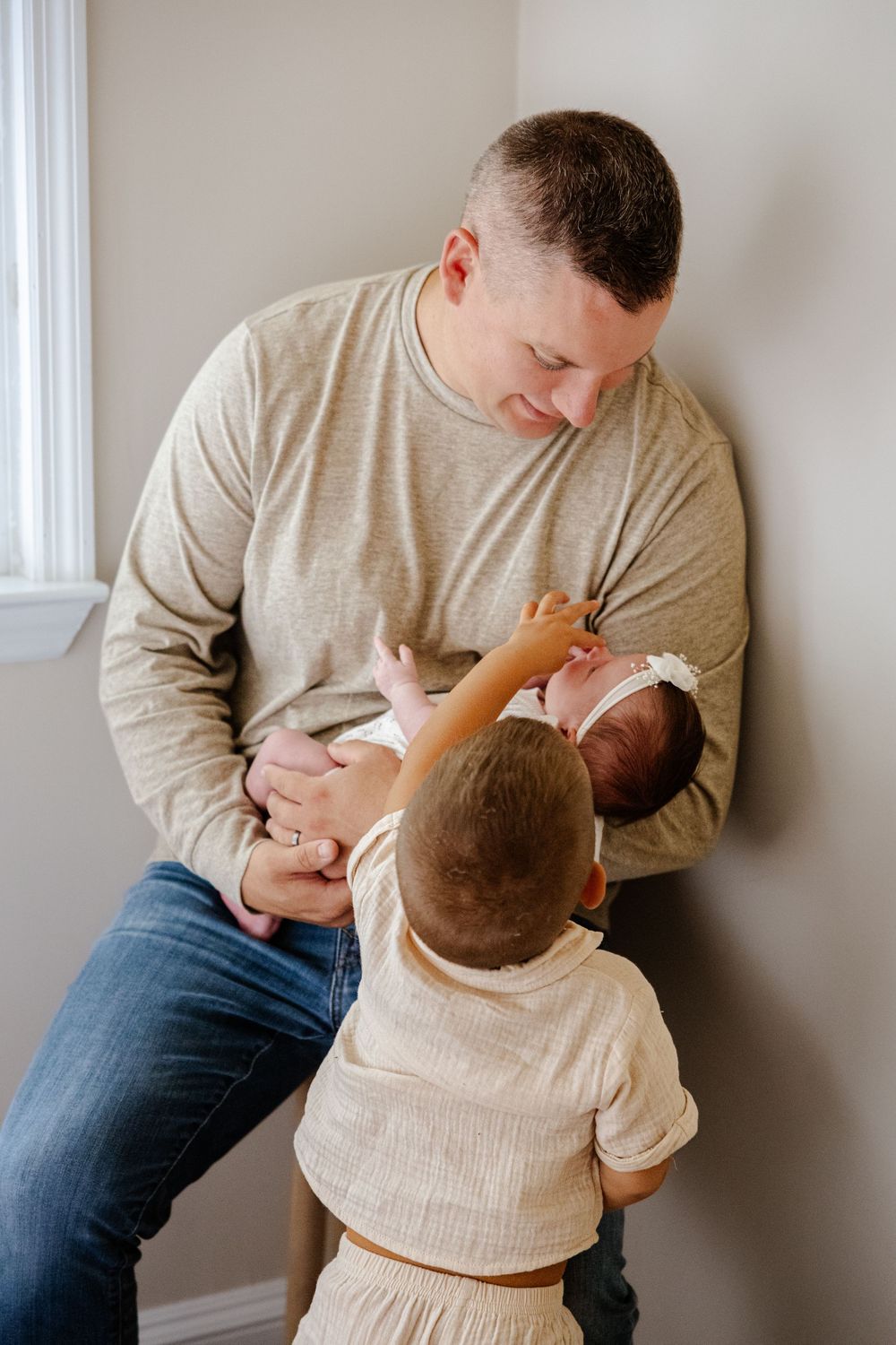Tender family moment captured in soft natural lighting indoors.