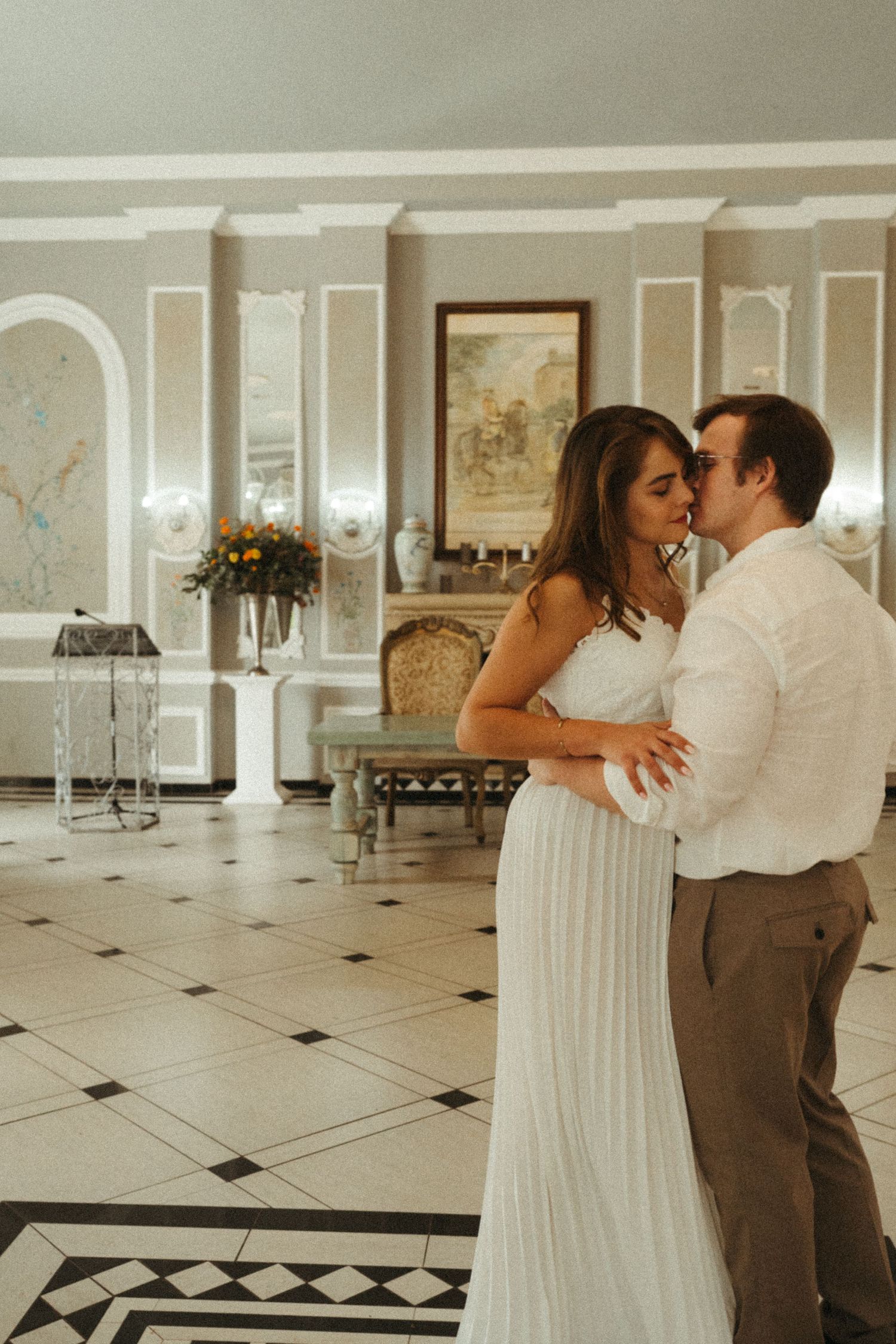 Romantic dance sequence in a grand ballroom with checkered floors.