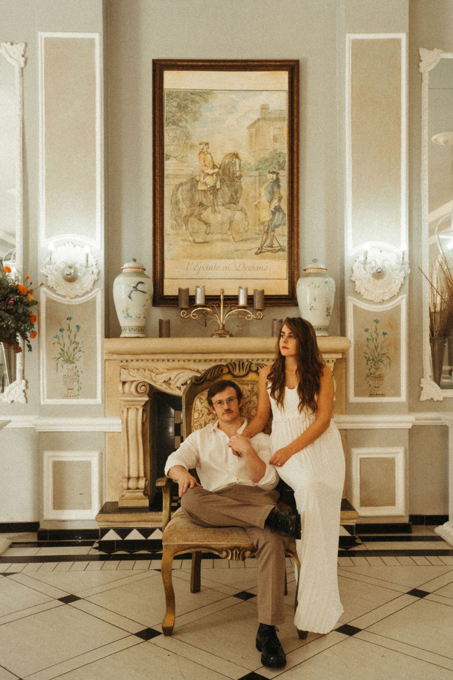 Two people dance together in a vintage-styled room with decorative wall panels.