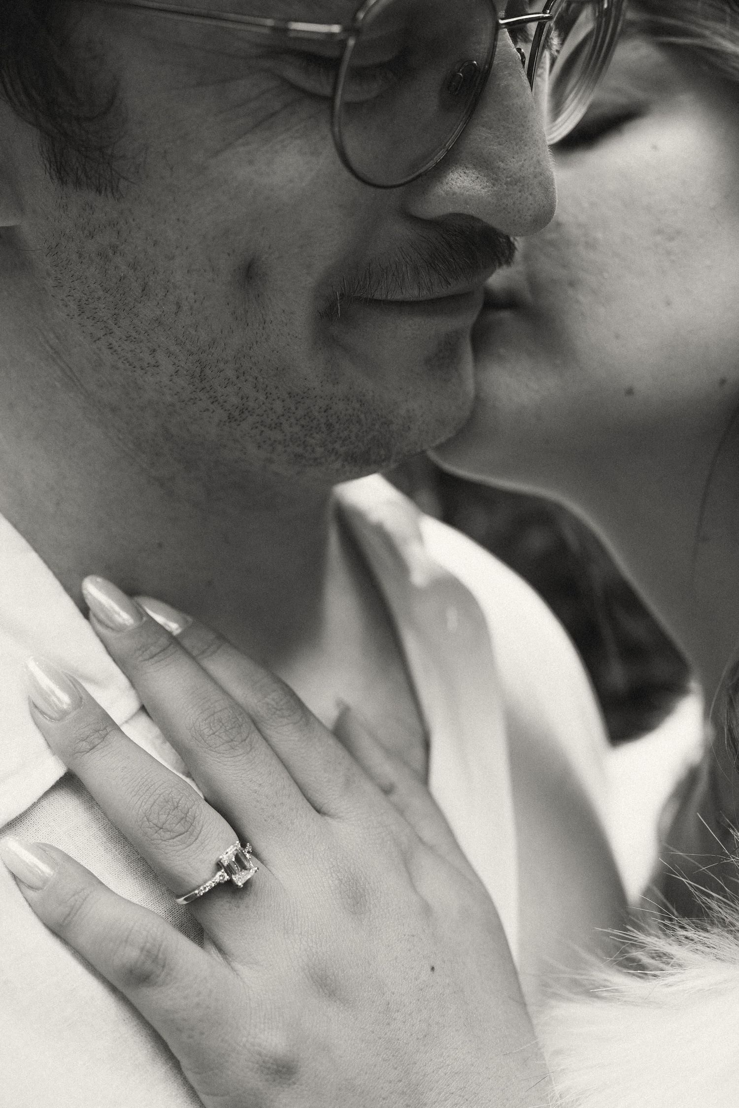 Close-up series showing tender kisses and a sparkling engagement ring.