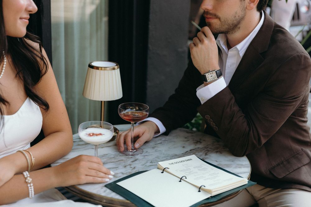 Business professionals sit at a table reviewing documents and discussing work during a meeting.