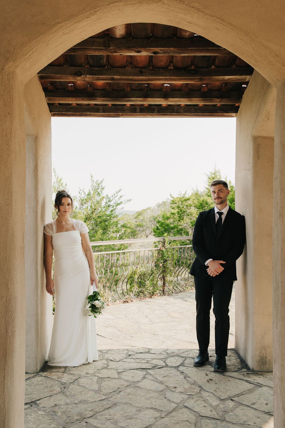 A series of wedding photos captured under stone archways with columns, showing couple in formal attire.