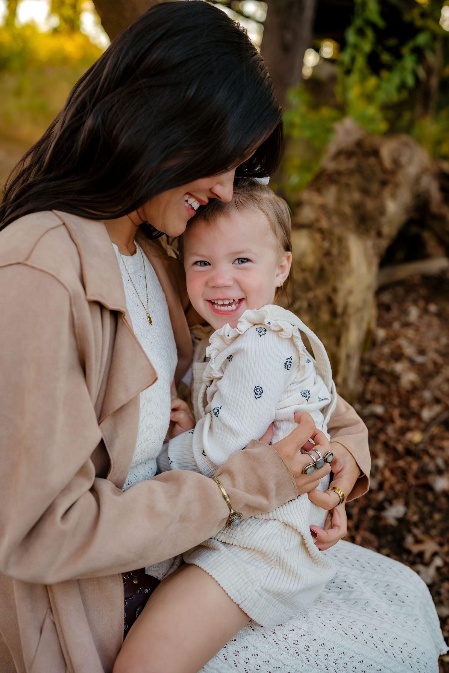 A tender family moment captured outdoors with warm lighting and natural surroundings.