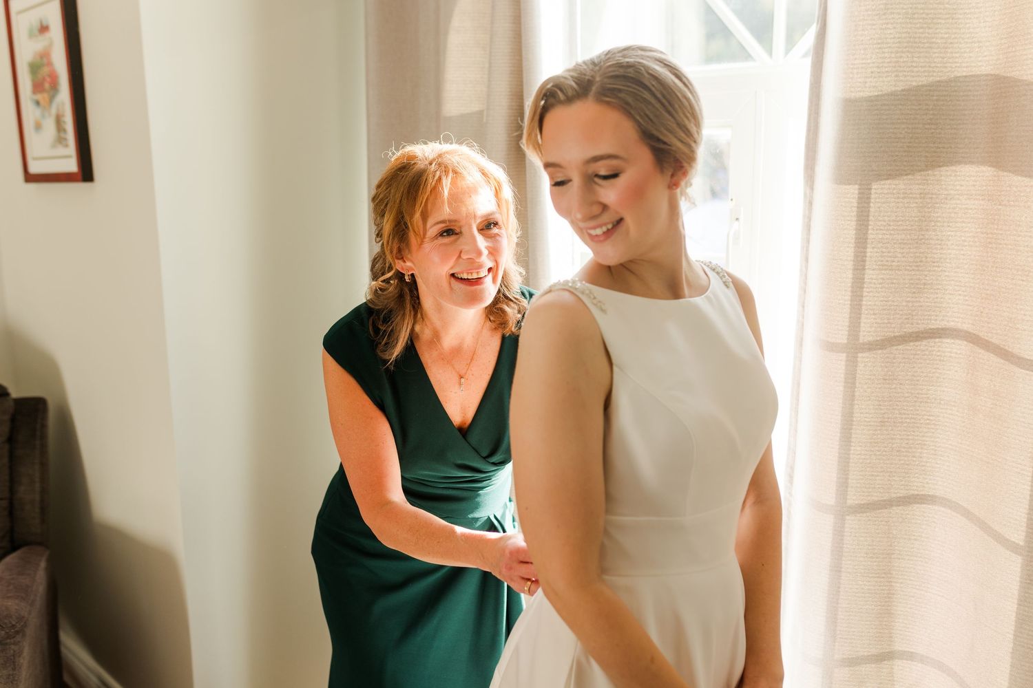 A couple in green and white outfits dance together in an elegant indoor setting.