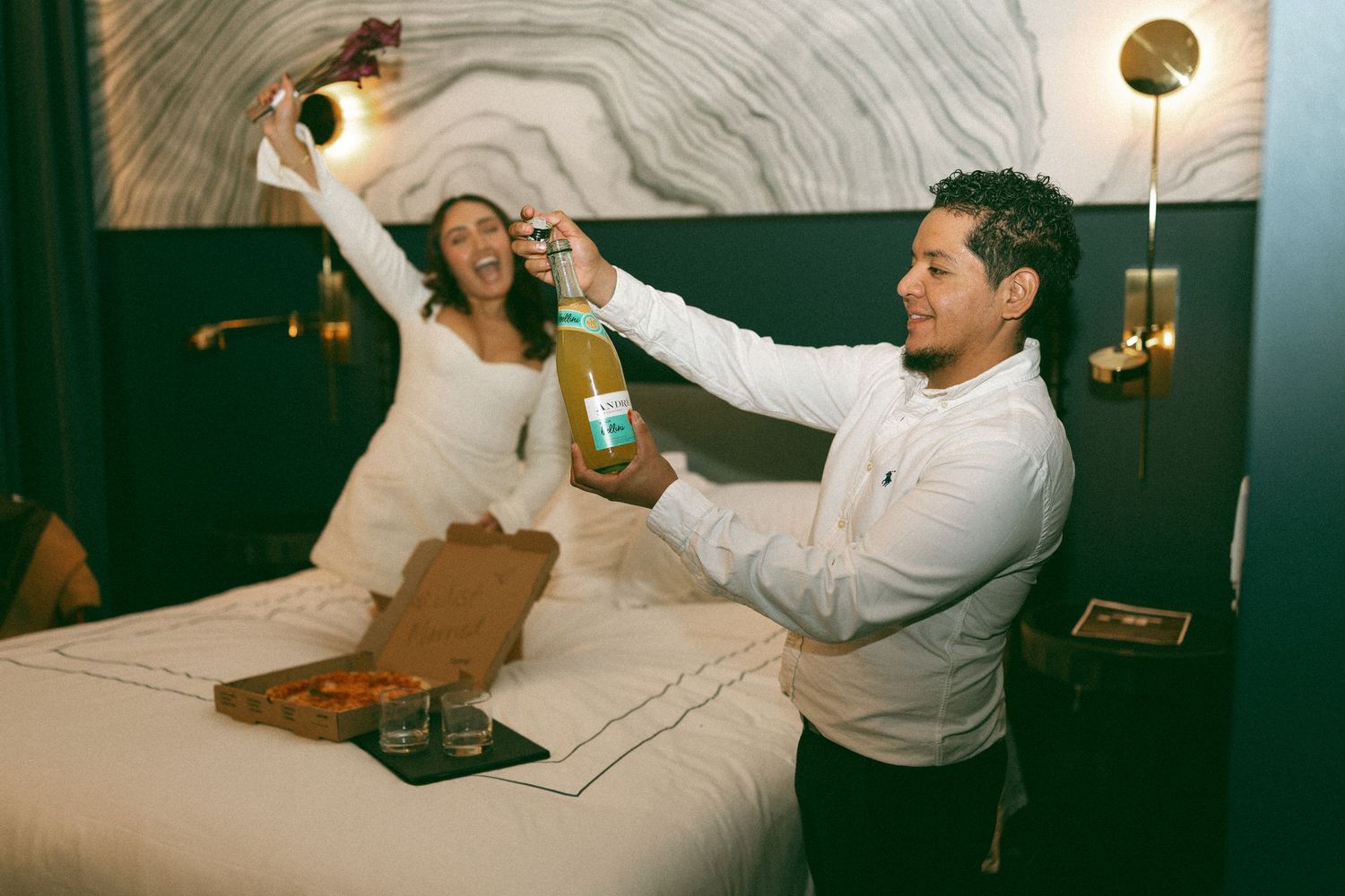 couple eloping in nashville, popping champagne and celebrating with pizza. elopement photographer Karla Derry
