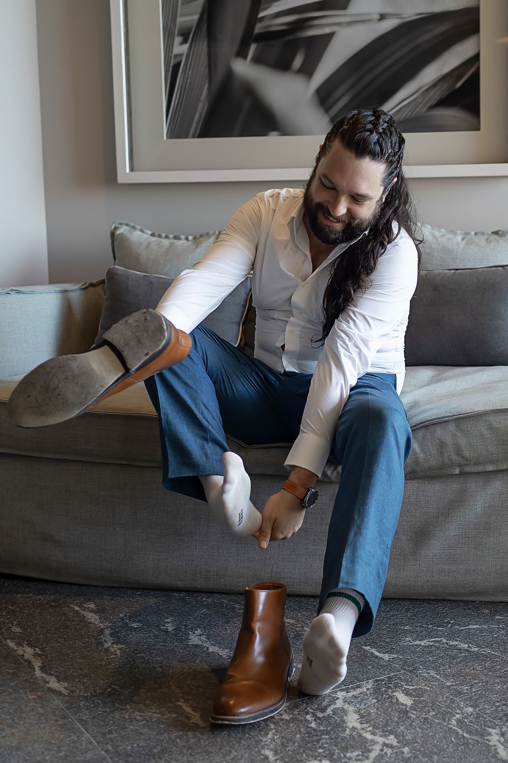 Groom putting on boots while getting ready at Secrets Moxché destination wedding.