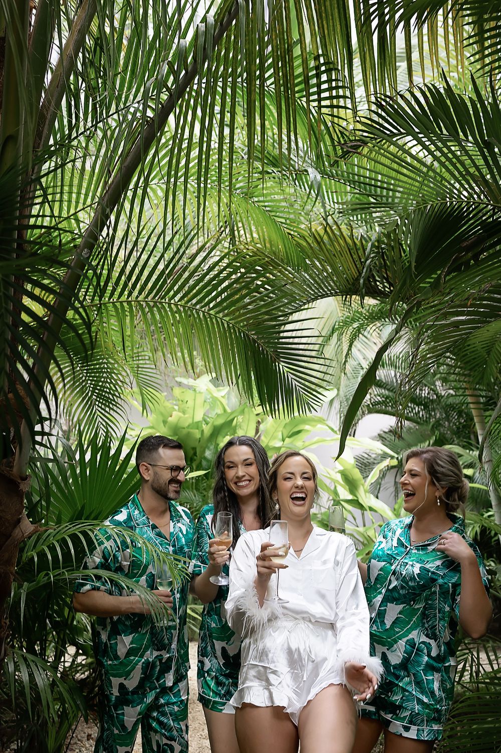 Bride laughing with friends in tropical setting at Secrets Moxché destination wedding.
