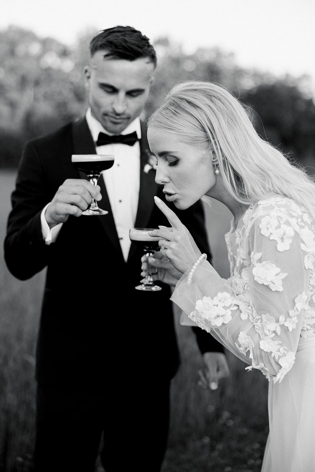 A romantic black and white photo series of a couple in wedding attire sharing a champagne toast outdoors.