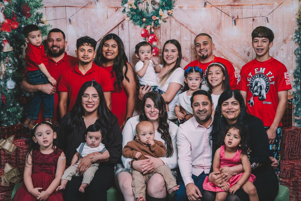 Large family group photo with everyone wearing coordinating red outfits for Christmas.