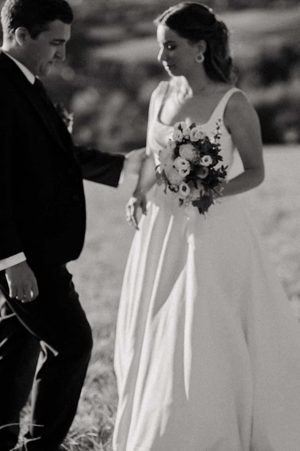une photo en noir et blanc d'un couple de mariés ou la mariée tient son bouquet