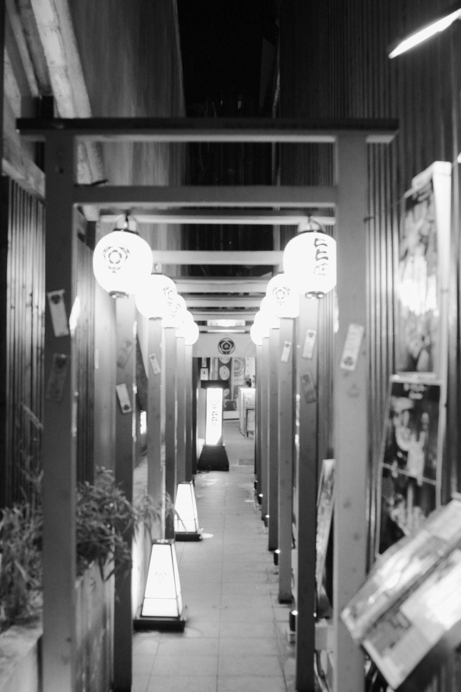 A dark tunnel-like hallway with arched ceilings and warm glowing lights creates an atmospheric architectural perspective.
