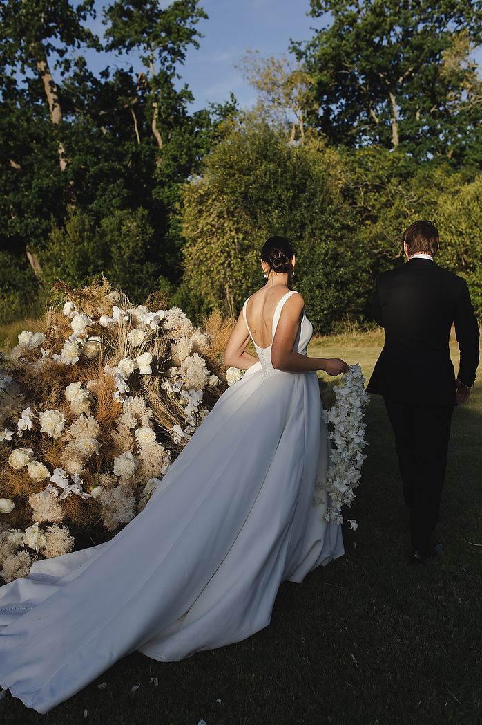 The couple walking through vineyards during sunset.