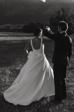 Groom spinning bride at golden hour.