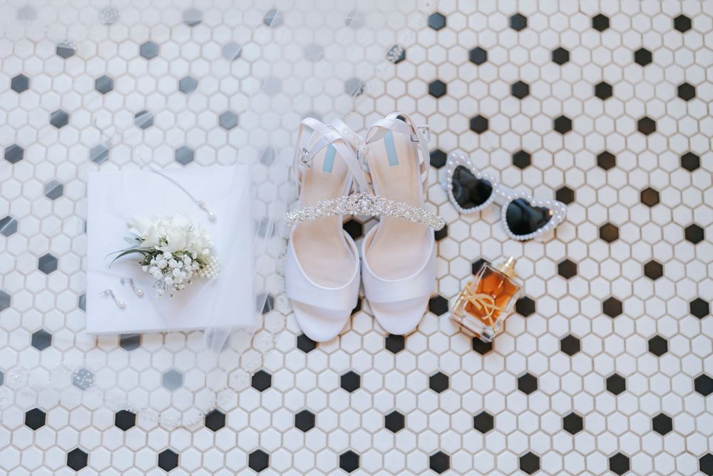 White hands with colorful nail polish press against a polka dot pattern surface, creating an artistic composition.