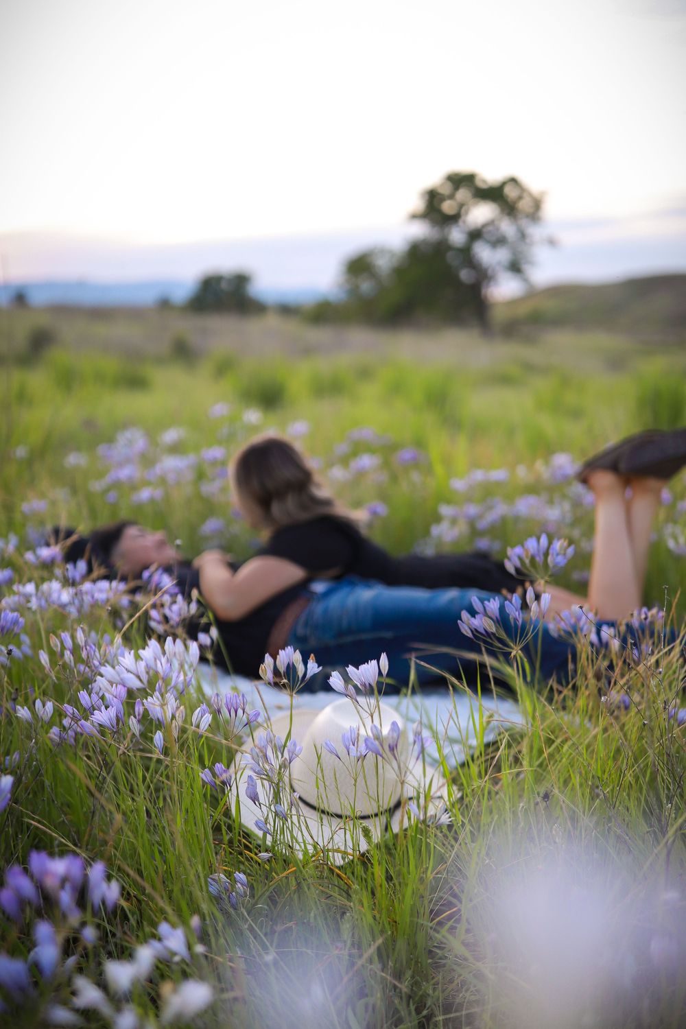 Purple wildflowers bloom in a meadow during a romantic outdoor photoshoot.