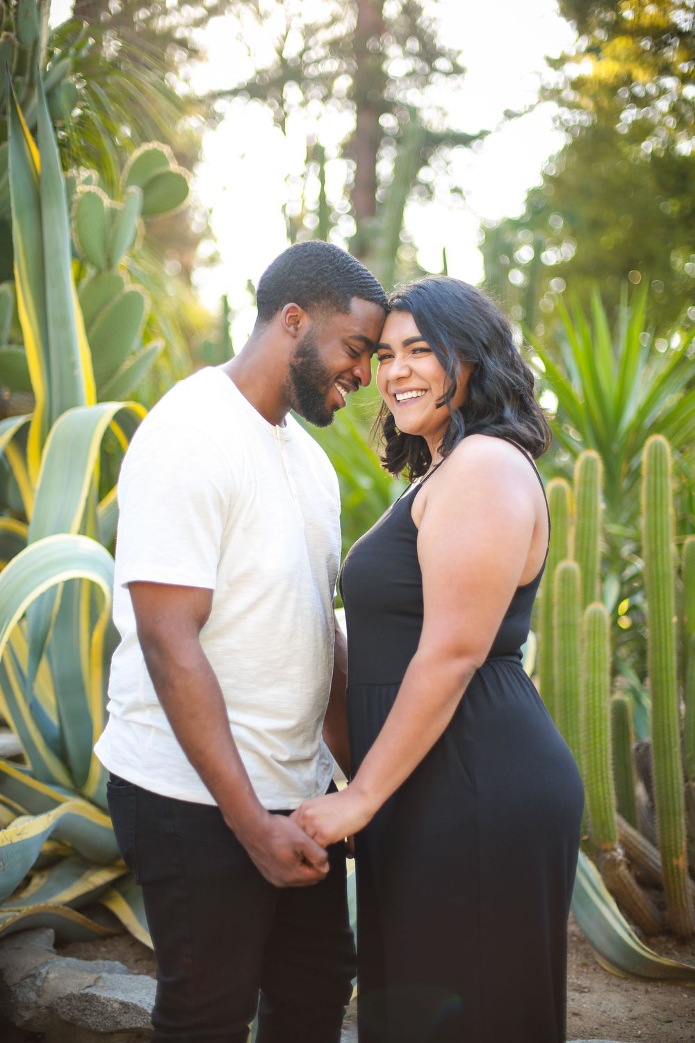 Couple sharing intimate moments in a desert garden with agave plants.