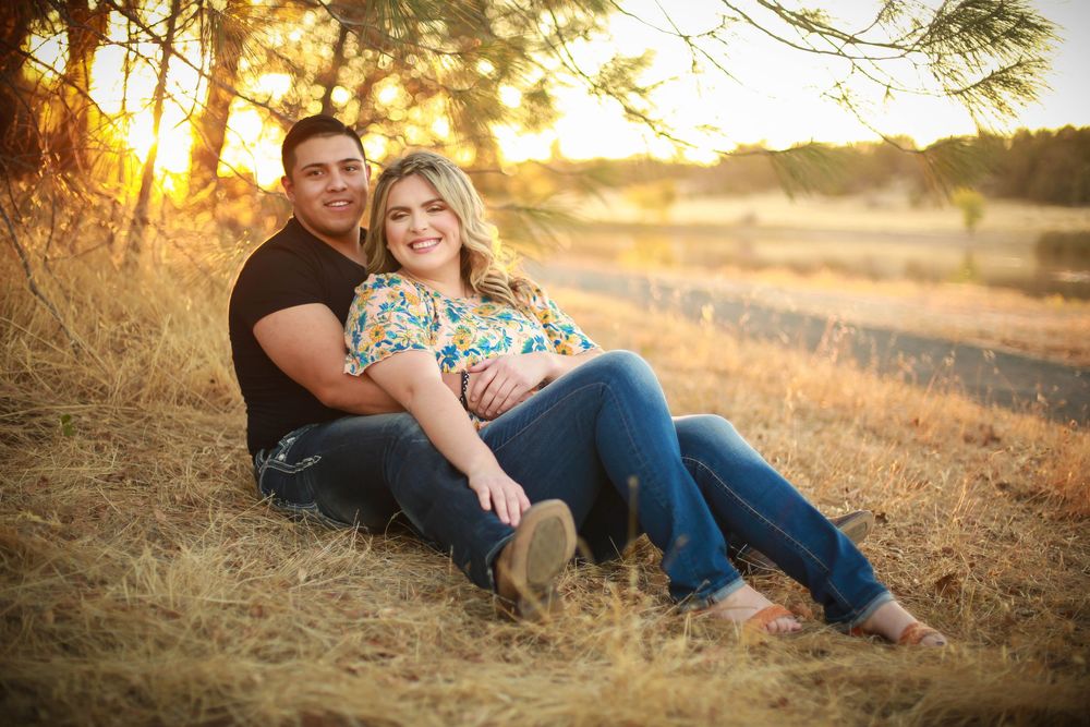 Couple relaxing together in a golden field during sunset.