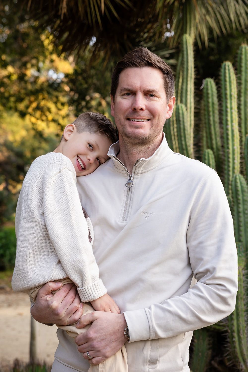 Bay Area dad holds his son who smiles while resting his head on his shoulder