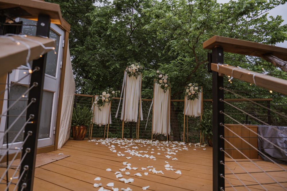 White flower petals scattered across a wooden deck platform outdoors.