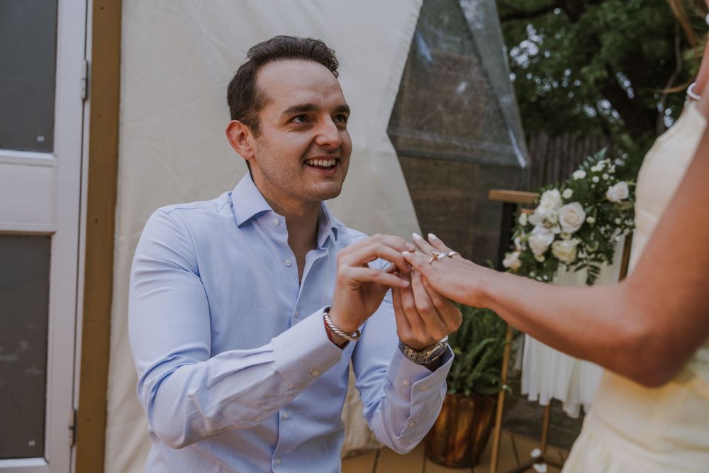 A couple shares joyful laughter during their outdoor wedding celebration.