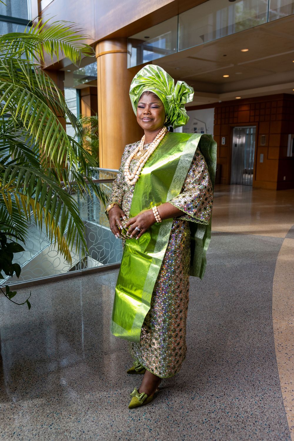 Traditional African attire featuring bright lime green and floral prints displayed in a hallway setting.