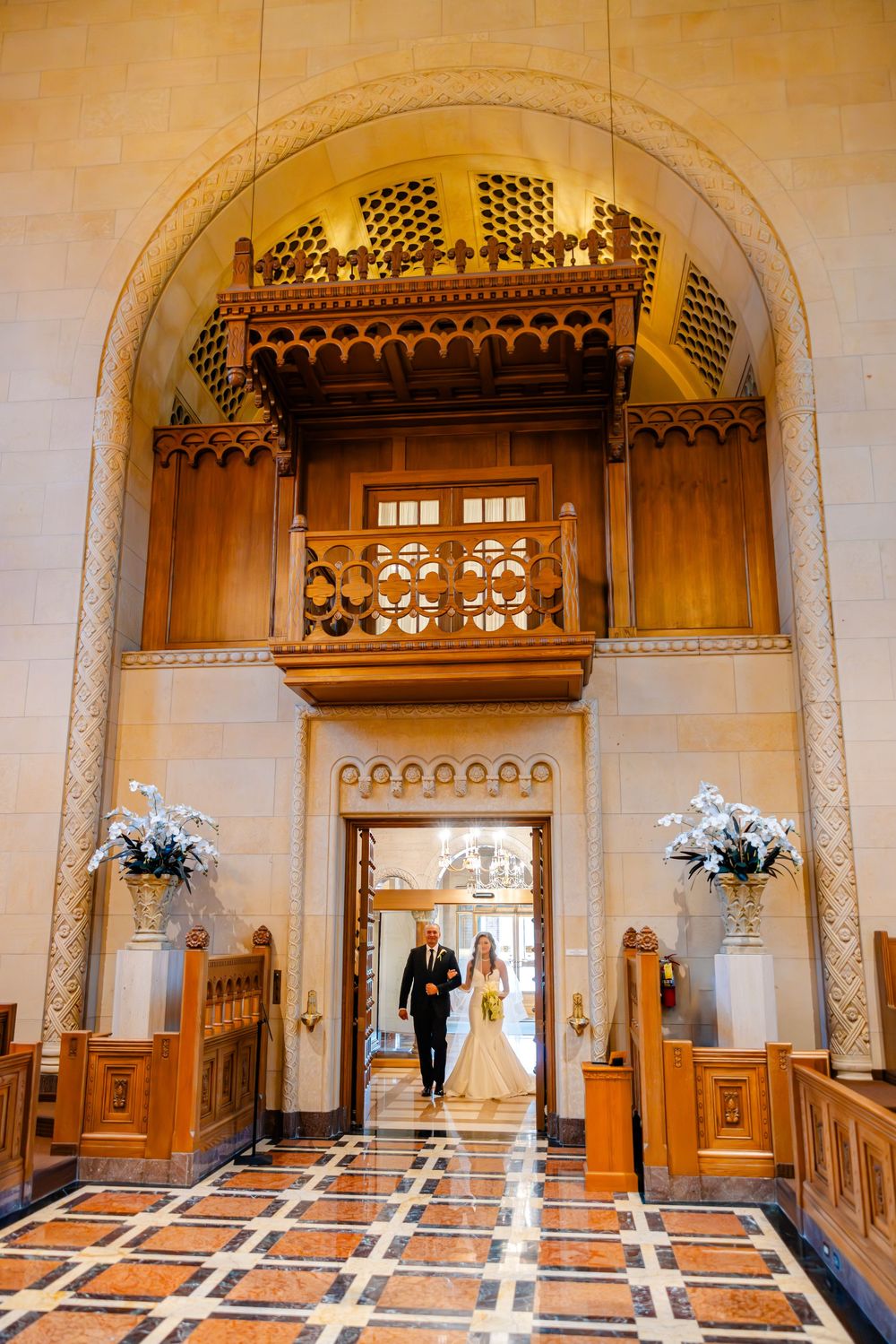 Elegant church interior with arched doorways and ornate wooden details illuminated in warm golden lighting.