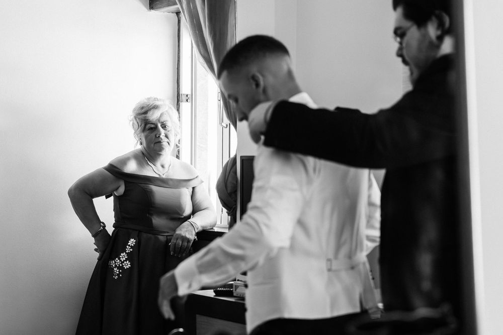 Two people in black and white prepare food in a kitchen setting.