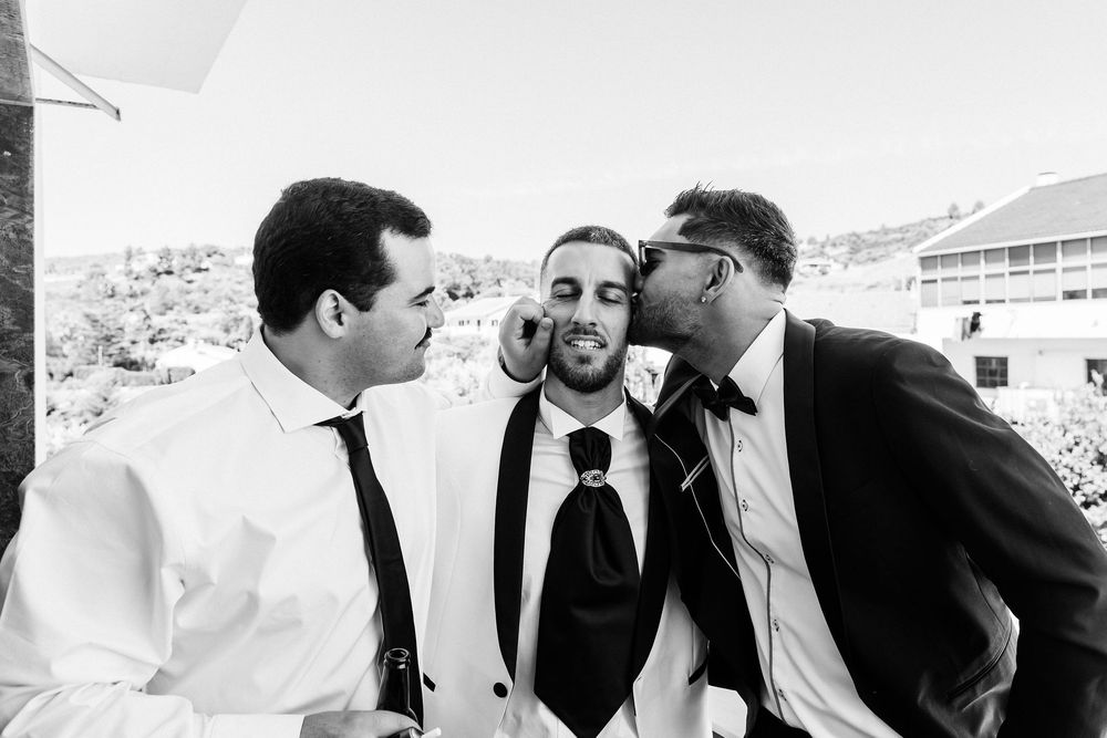 Wedding party members share laughter and conversation during an outdoor celebration.