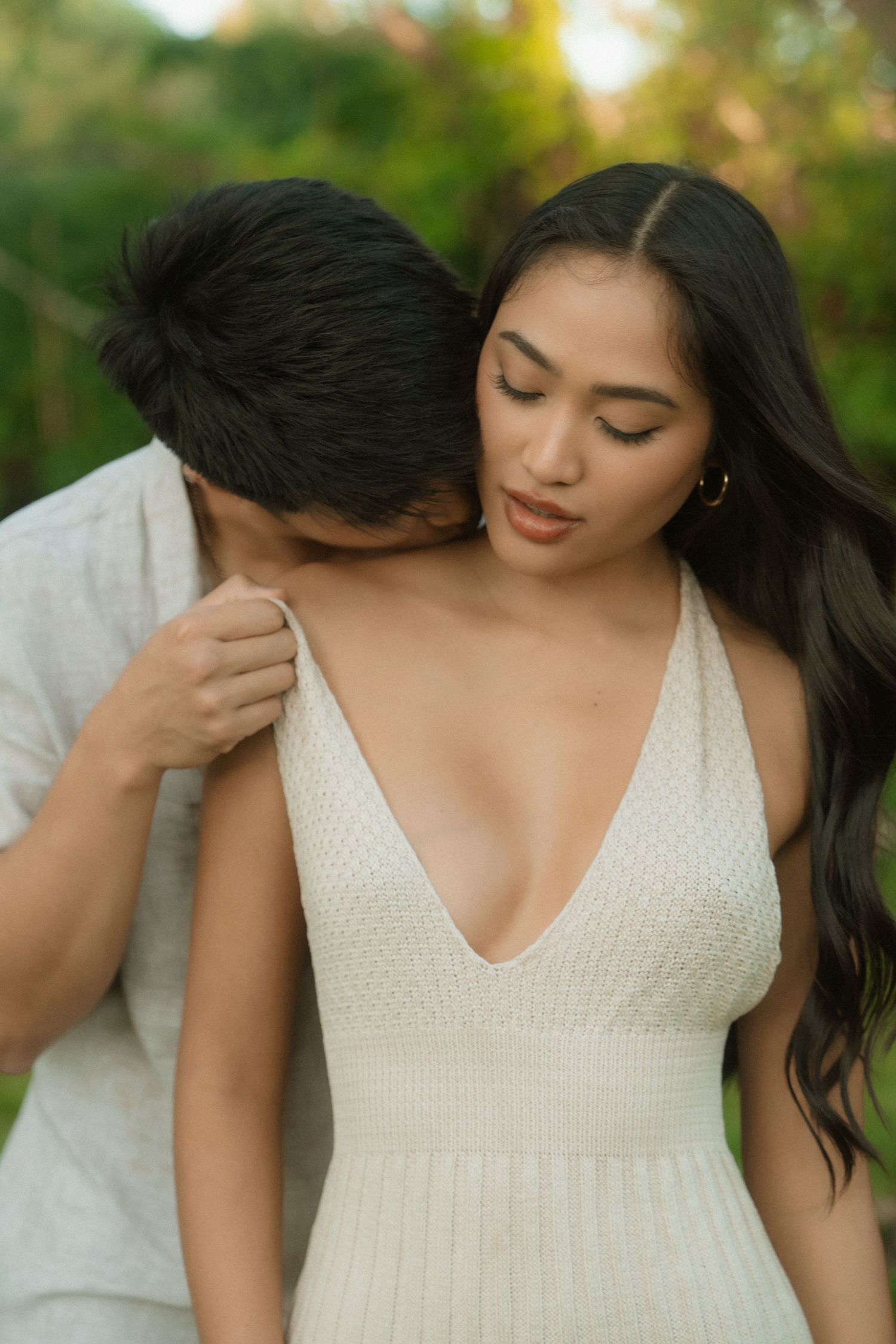 Close-up of hands reaching towards each other in a dreamy outdoor setting.