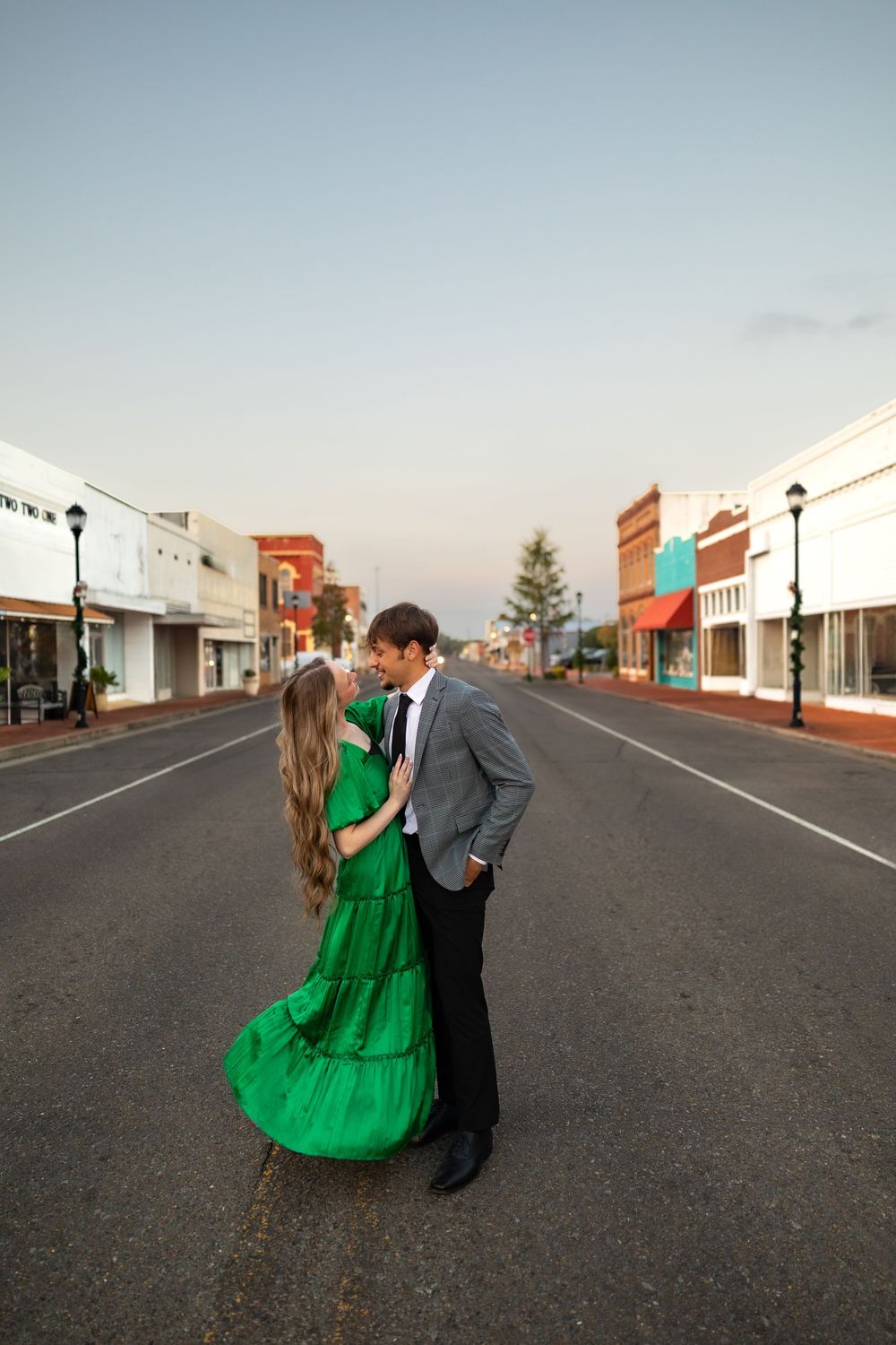 Romantic couple embrace in middle of empty downtown street.
