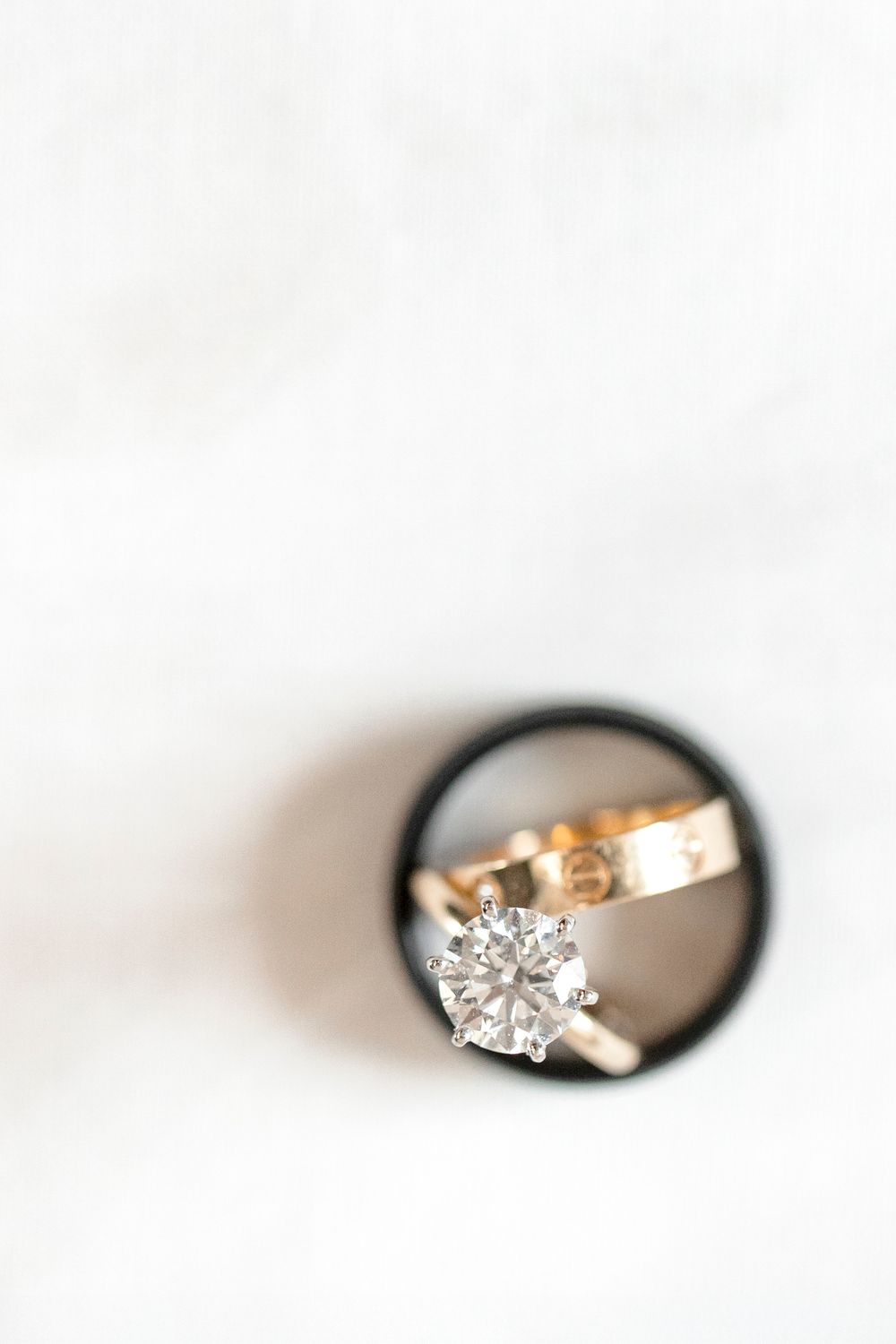 Close-up view of elegant diamond engagement rings on a light neutral background.