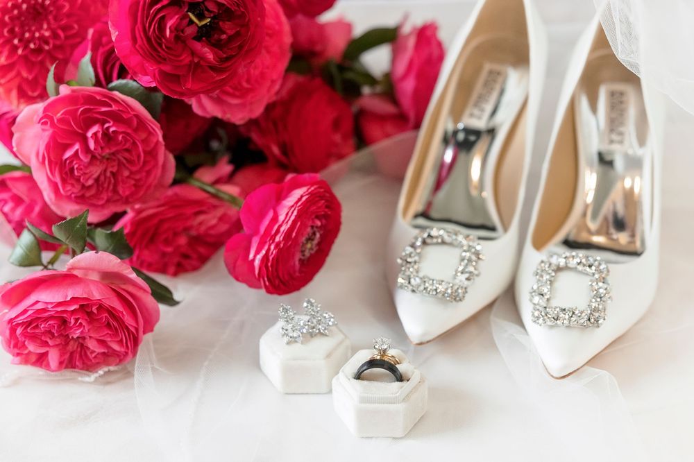 Bridal accessories featuring pink roses, silver high heels, and sparkly jewelry against a white background.