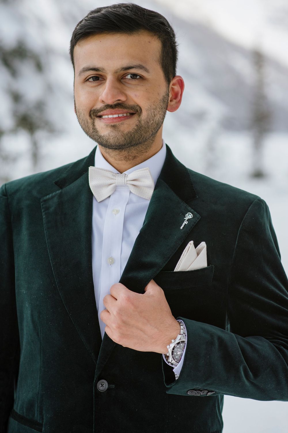 Groom to  to be and Snow covered Fairmont Chateau Lake Louise with mountains and frozen lake during winter photoshoot