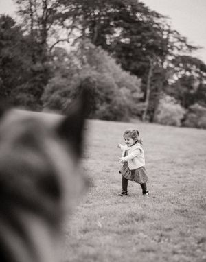 Black and white sequence of photos showing someone rolling down a grassy hill in a playful manner.