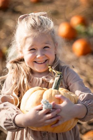 A series of four connected photos showing joyful moments outdoors with autumn gourds in warm sunlight.