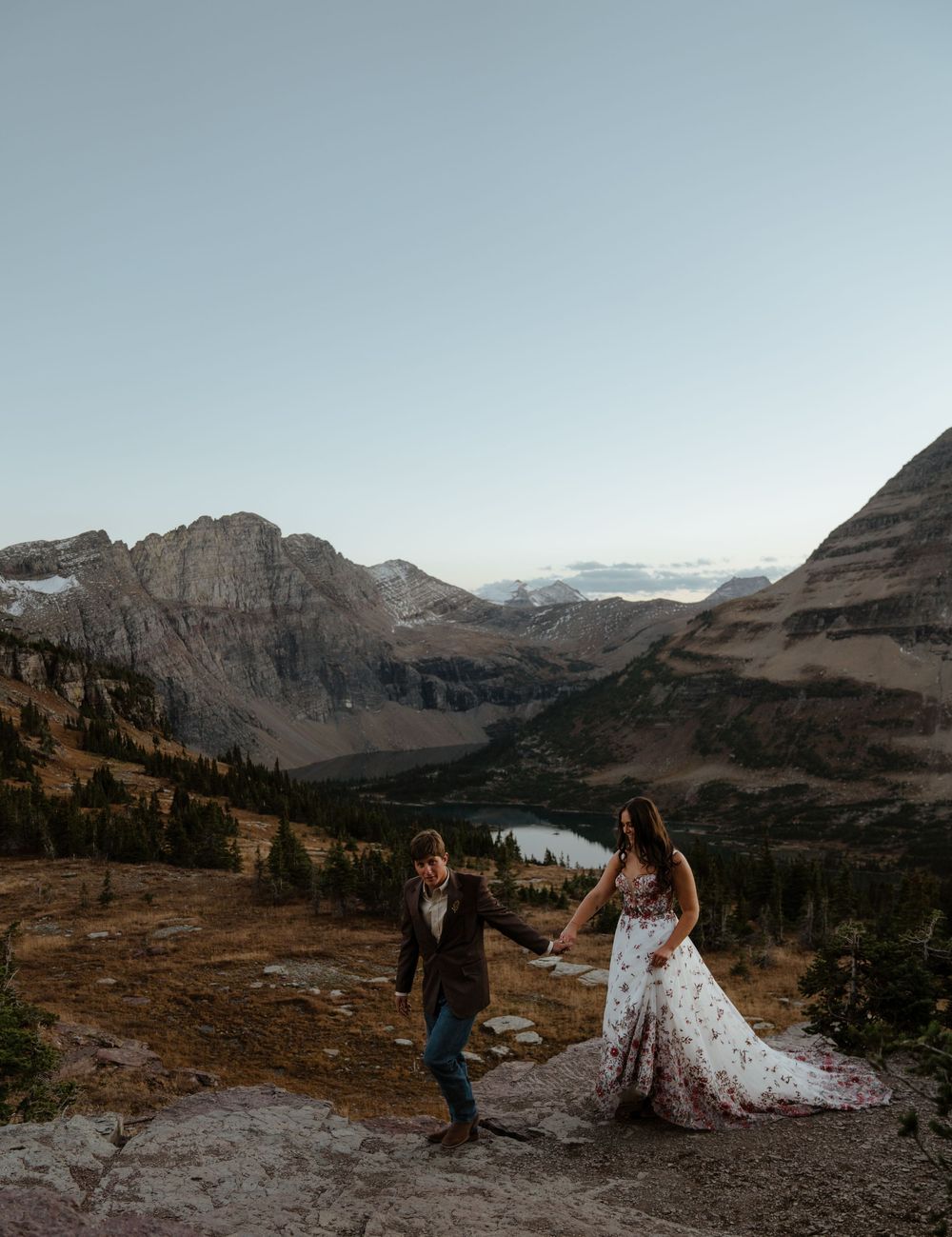 A couple shares an intimate moment at sunset overlooking Hidden Lake in Glacier National Park after sunset.