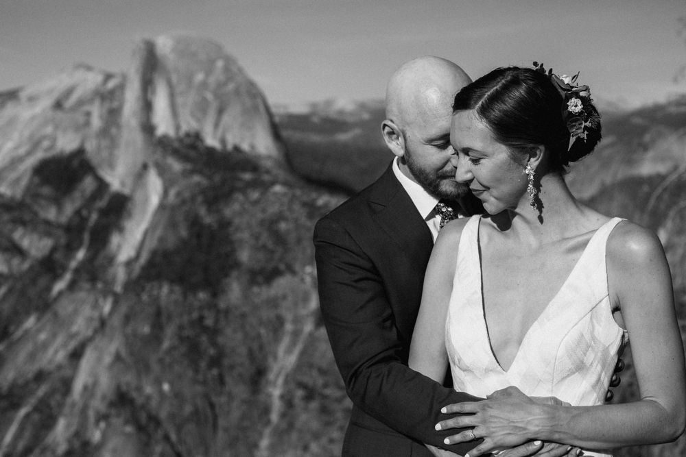 A tender black and white wedding portrait captured in front of Half Dome at Yosemite National Park.