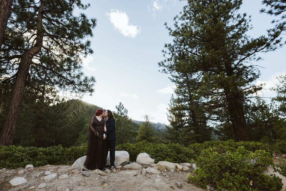 Couple sharing a romantic moment among tall pine trees and rocky landscape in a mountain forest setting in the mountains of Lake Tahoe