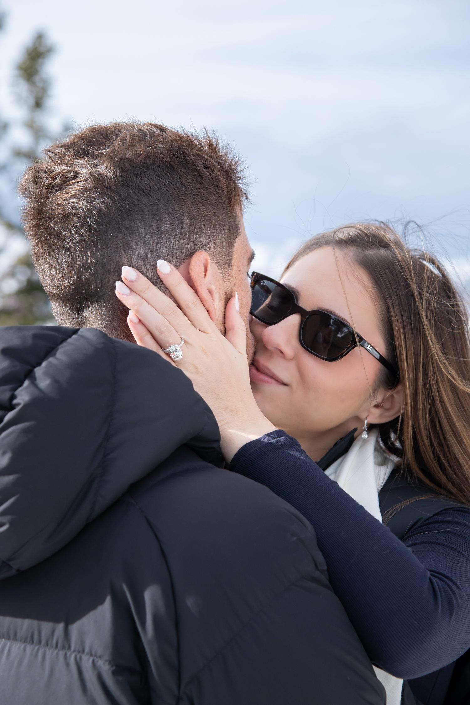 A romantic photo showing a couple sharing an intimate kiss during engagement photos on top of Aspen mountain.