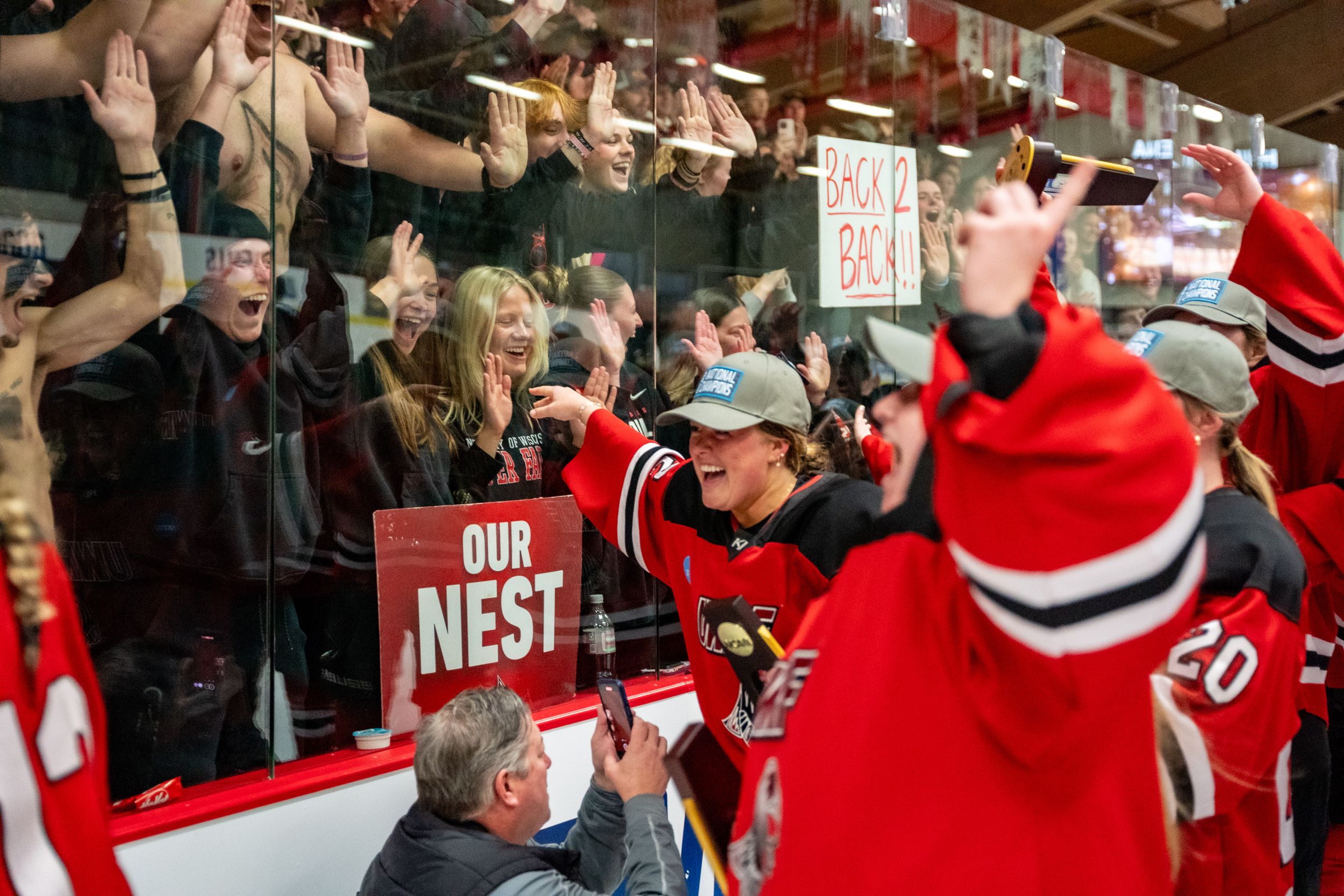 Excited hockey fans cheer and celebrate from the stands during a Carolina Hurricanes NHL game.