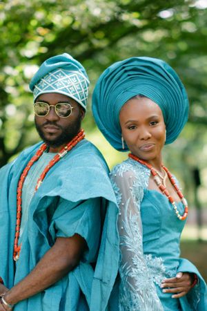 A close-up portrait of a couple in traditional turquoise Nigerian wedding attire with beaded accessories.