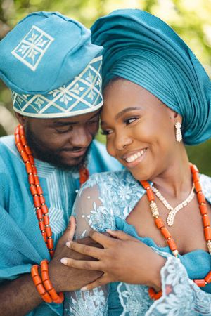 Close-up of couple in teal traditional attire sharing an intimate moment.