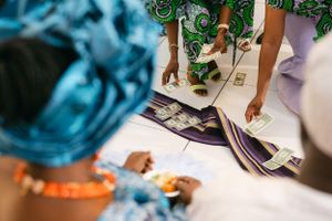 Close-up view of hands handling money during a traditional ceremony.