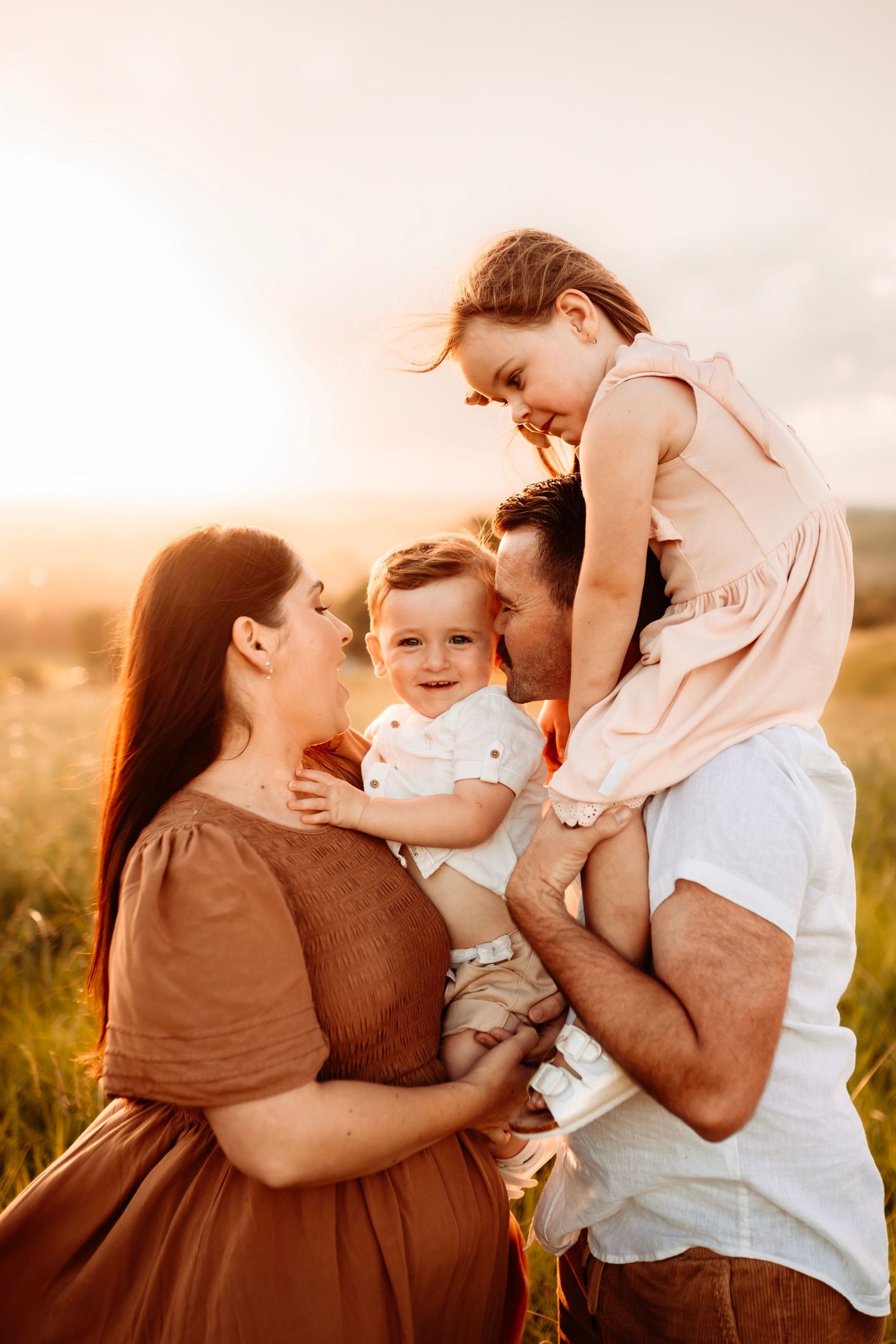 Family sharing joyful moment together during golden hour outdoor photo session.