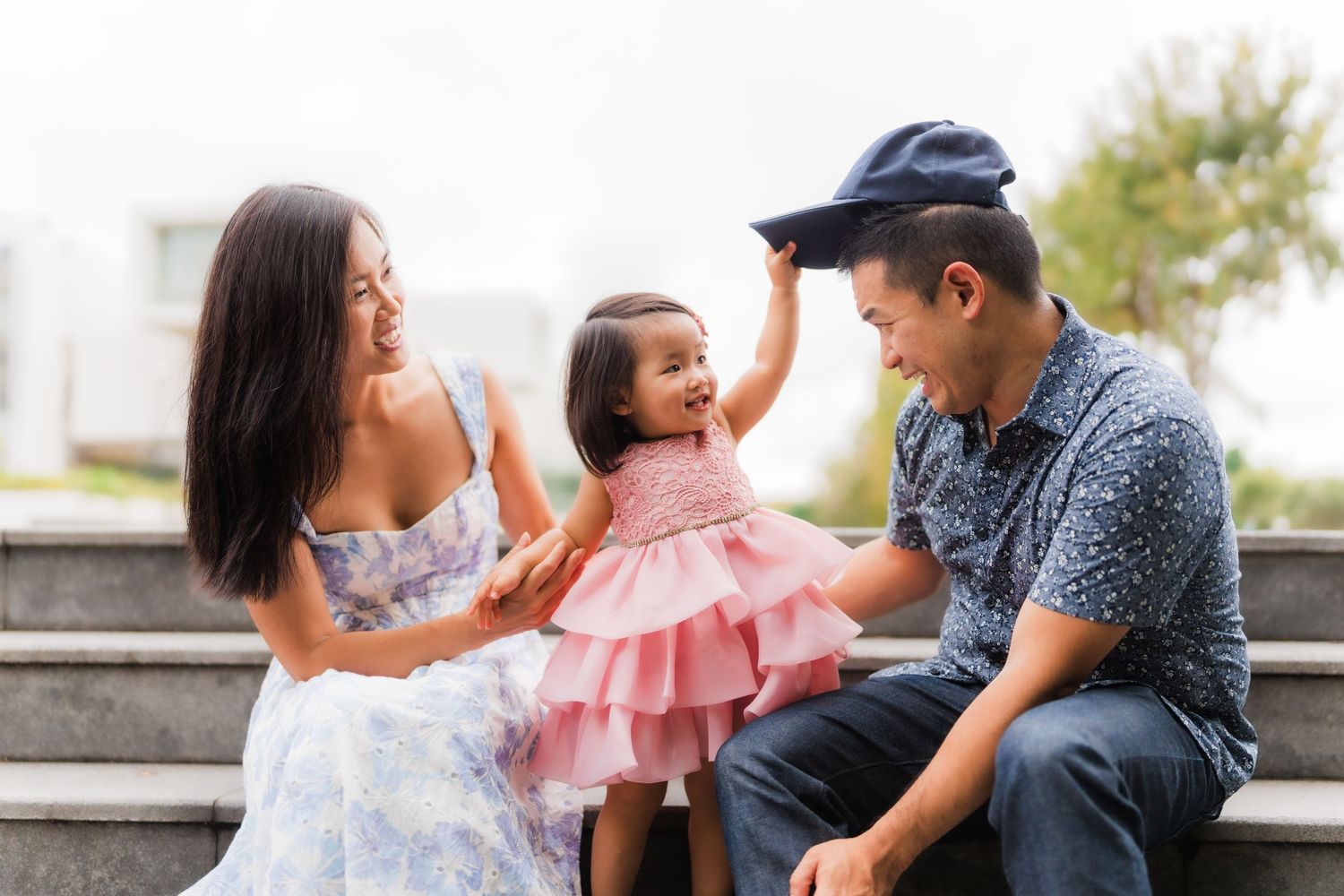 A family sharing a playful moment together on stone steps outdoors.